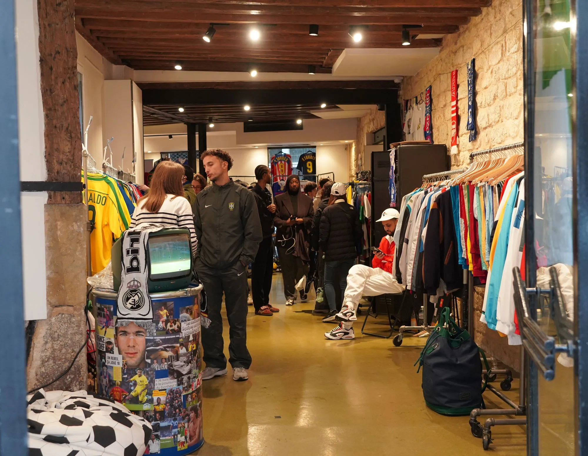 La boutique d’Avant Garde pleine de visiteurs, entre les portants de maillots vintage