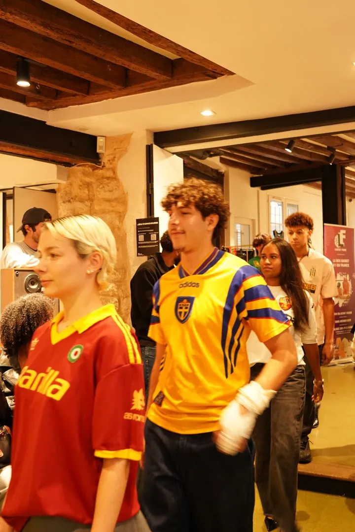 Mannequins en maillots de football vintage défilant au milieu du public dans la boutique